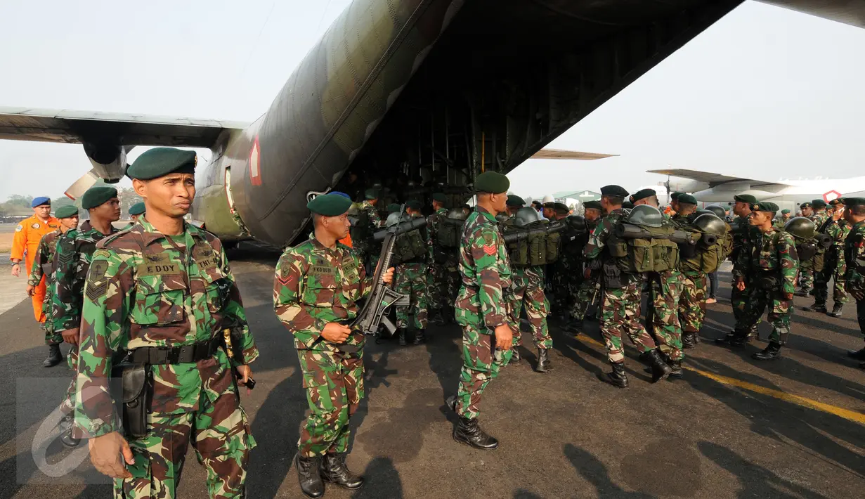 Anggota TNI yang tergabung dalam Satgas Pemadaman Kebakaran Hutan dan Lahan mengawasi proses loading pesawat Hercules di Lanud Halim Perdanakusuma Jakarta, Selasa (27/10/2015). 1000 personil TNI kembali diberangkatkan. (Liputan6.com/Helmi Fithriansyah)
