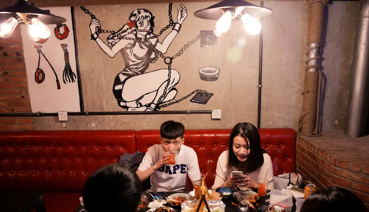 Pengunjung menikmati hidangan di restoran Ke'er di Beijing, China (26/5). Restoran bertema seks ini menyajikan menu hidangan seafood yang disajikan di atas piring dan gelas berbentuk payudara dan alat kelamin pria. (REUTERS/Kim Kyung-Hoon)