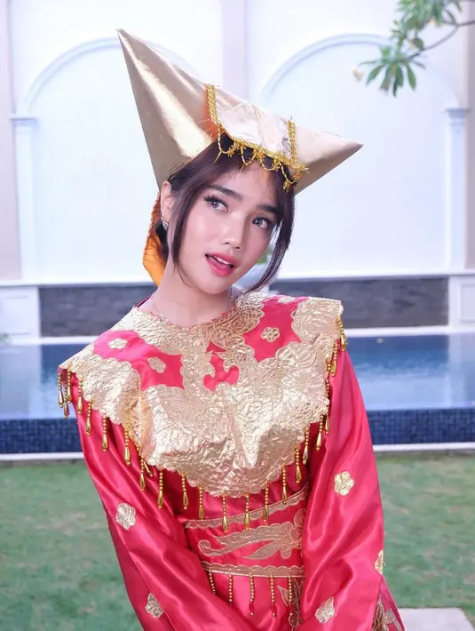 Fuji Utami tampil mengenakan busana adat Minang dengan nuansa merah emas yang menyala [@fuji_an]