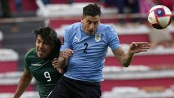 Pemain Bolivia Marcelo Martins (kiri) dan pemain Uruguay Jose Gimenez melakukan sundulan pada pertandingan kualifikasi Piala Dunia 2022 di Stadion Hernando Siles, La Paz, Bolivia, 16 November 2021. Bolivia menang 3-0. (AP Photo/Juan Karita)