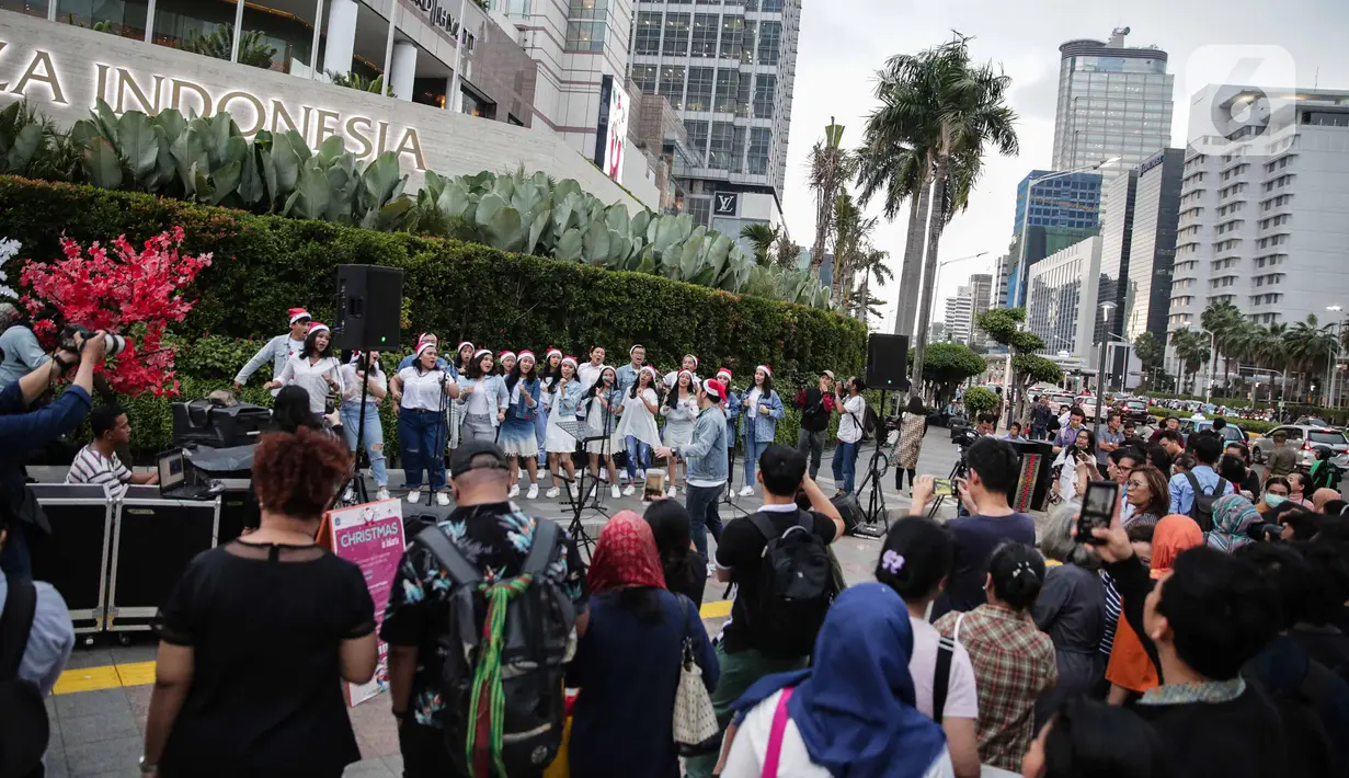 Suasana saat paduan suara Christmas Carol menghibur pengguna jalan di depan pedestrian Plaza Indonesia, Jakarta, Rabu (18/12/2019).  Terdapat 11 titik Christmas Carol di sepanjang Jalan Sudirman – MH Thamrin dan stasiun MRT. (Liputan6.com/Faizal Fanani)