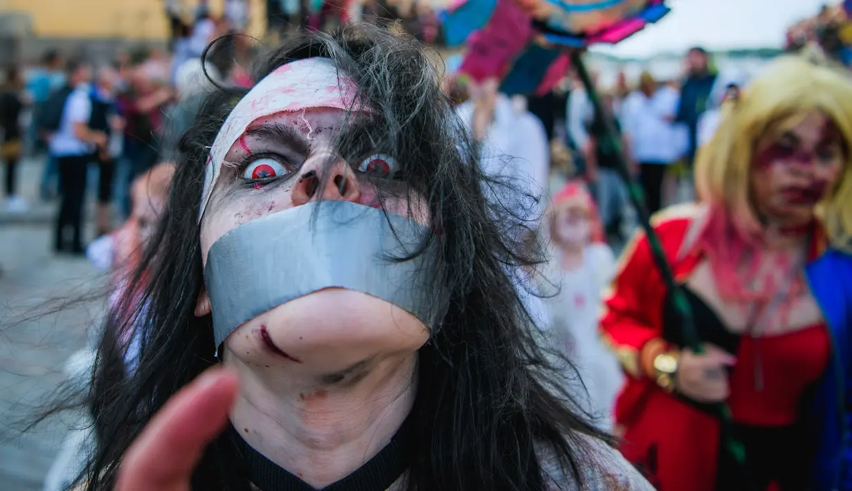 Seorang pria menggunakan kostum seperti zombie berjalan di tengah kota dalam parade "Zombie Walk" di Stockholm, Swedia, Sabtu (19/8). Zombie Walk adalah acara yang rutin dilakukan saat musim panas tiba, tepatnya akhir Agustus. (Jonathan NACKSTRAND/AFP)
