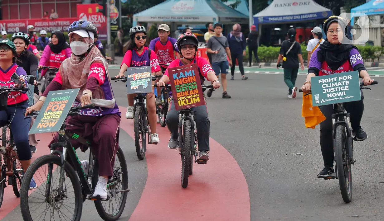 Aktivis dari berbagai penggiat lingkungan melakukan aksi damai di Hari Bebas Kendaraan (Car Free Days) di kawasan Bundaran HI, Jakarta,  Minggu (12/3/2023). Selain memperingati Hari Perempuan Internasional, aksi Women Pedal for People Planet tersebut dilakukan guna mengajak masyarakat untuk melakukan perlawanan terhadap krisis iklim yang berdampak pada kehidupan manusia dan ekologi. (Liputan6.com/Angga Yuniar)