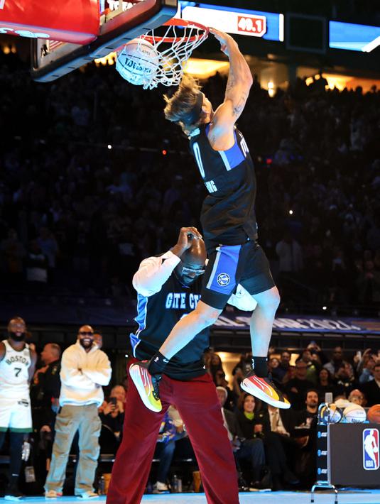 Pemain Osceola Magic, Mac McClung (atas) melompati mantan pemain NBA, Shaquille O'Neal saat kontes Slam Dunk di NBA All Star 2024 di Lucas Oil Stadium, Indianapolis, Amerika Serikat, Minggu (18/02/2024). (AFP/Getty Images/Stacy Revere)