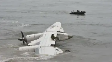 Pasukan keamanan berlayar di lepas pantai Port-Bouet,di dekat lokasi jatuhnya pesawat kargo Antonov yang menewaskan 4 orang warga Moldovan di Abidjan (14/10). Pesawat tersebut jatuh akibat dihantam ombak Pantai Gading. (AFP PHOTO / Sia KAMBOU)