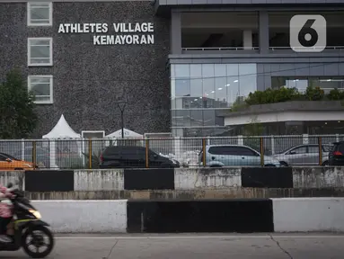 Pengendara motor melintas di depan Wisma Atlet, Kemayoran, Jakarta, Jumat (20/3/2020). Pemerintah akan mengubah fungsi Wisma Atlet Asian Games sebagai rumah sakit darurat khusus penanganan virus corona (Covid-19) sehingga bisa dipakai pada Senin (23/3/2020). (Liputan6.com/Immanuel Antonius)