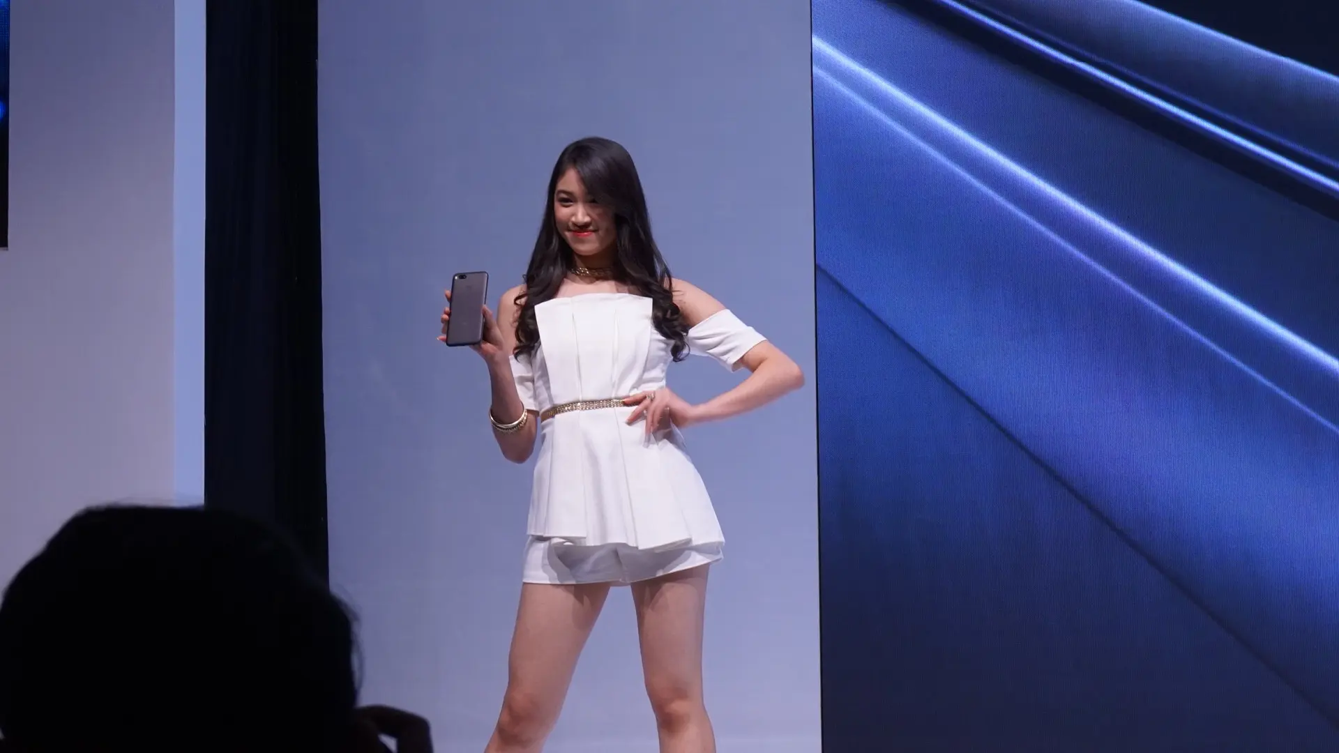 Member JKT48 Shani Indira memamerkan Mi A1 di panggung peluncuran Xiaomi Mi A1 (Liputan6.com/ Agustin Setyo W)