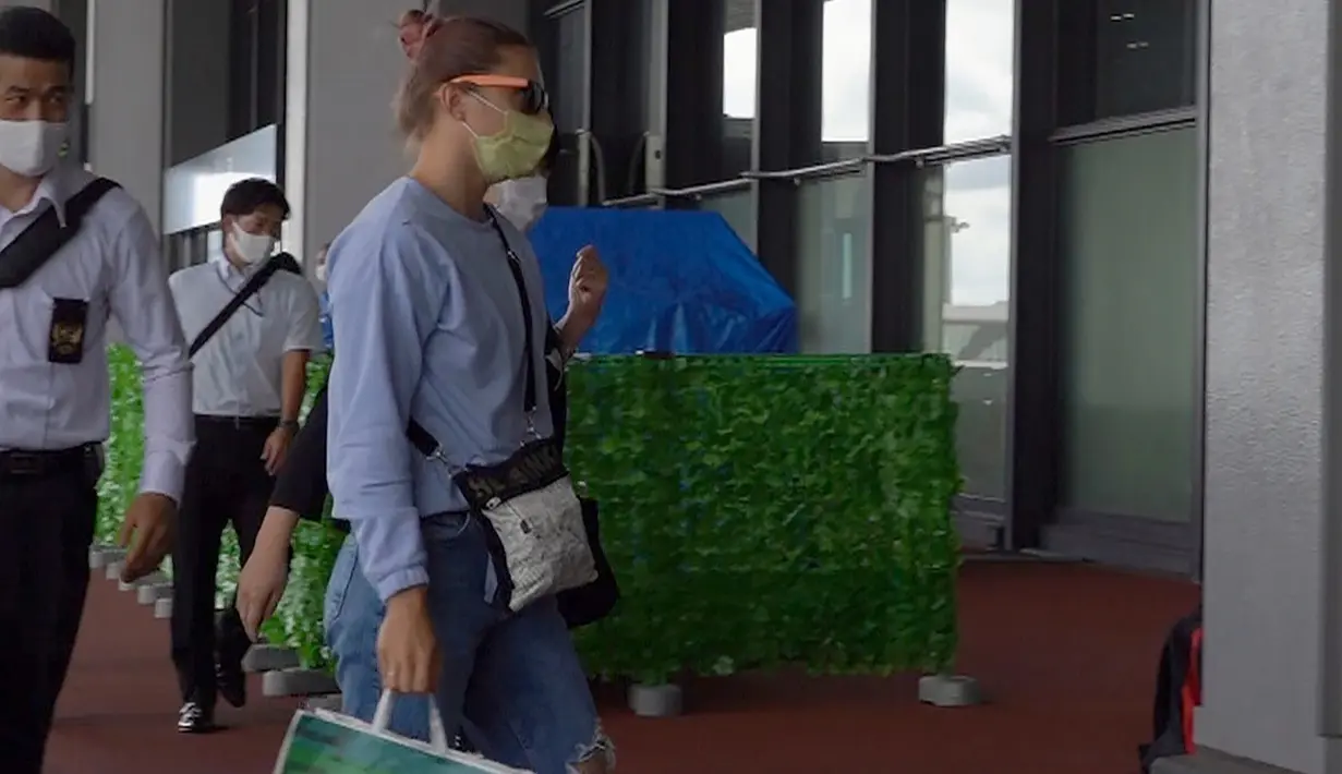 Atlet Olimpiade Belarusia, Krystsina Tsimanouskaya (kanan) tiba di Bandara Internasional Narita di Narita, dekat Tokyo, Rabu (4/8/2021). Sprinter 24 tahun itu telah mendapat visa kemanusiaan dari Polandia setelah dia menolak untuk pulang ke negaranya, pada 1 Agustus 2021. (AP Photo/Andrea Rosa)