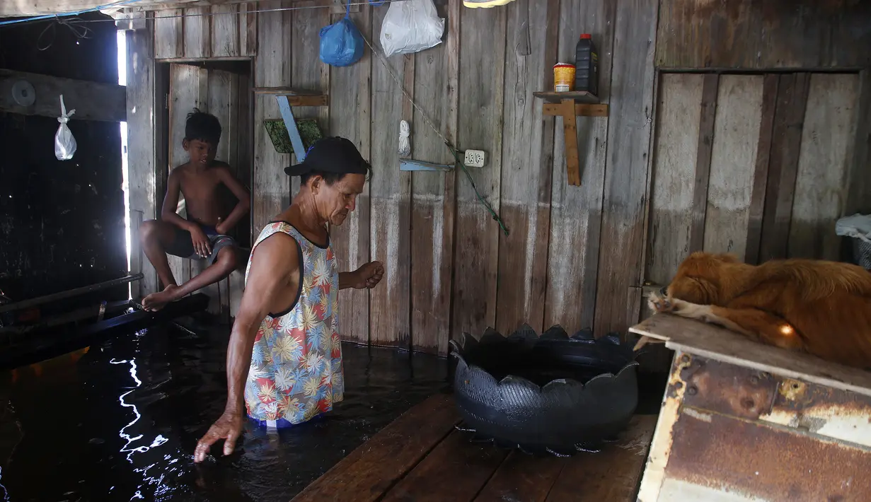 Raimundo da Silva Reis berjalan di rumahnya, dibanjiri oleh naiknya sungai Negro di Iranduba, negara bagian Amazonas, Brasil, Senin (23/5/2022). Wilayah Amazon sedang dilanda banjir dengan 35 kotamadya yang menghadapi salah satu banjir terburuk mereka dalam beberapa tahun dan permukaan air diperkirakan akan meningkat selama beberapa bulan mendatang. (AP Photo/Edmar Barros)