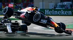 Alih-alih berhasil melewati Hamilton, mobil Verstappen malah bertabrakan hingga terangkat dan mendarat di atas rivalnya tersebut. Bahkan, sisi dalam ban mobil Verstappen mengenai helm Hamilton yang cukup beruntung terlindungi piranti halo. (Foto: AFP/Andrej Isakovic)