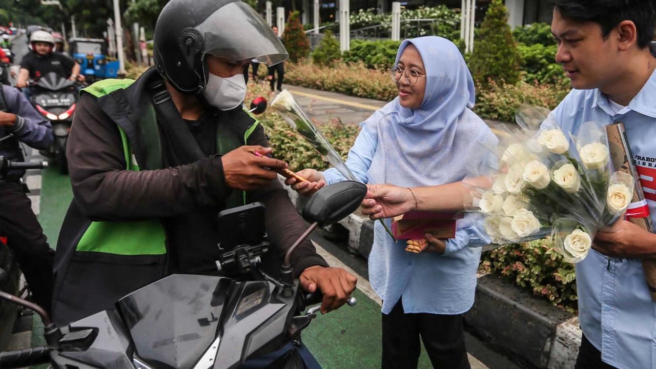 Tim Kampanye  Nasional (TKN) Pemilih Muda (Fanta) Prabowo-Gibran membagikan bunga mawar dan coklat kepada pengguna jalan di Kawasan Sarinah, Jakarta, Kamis (15/2/2024). Foto: Liputan6.com / Angga Yuniar