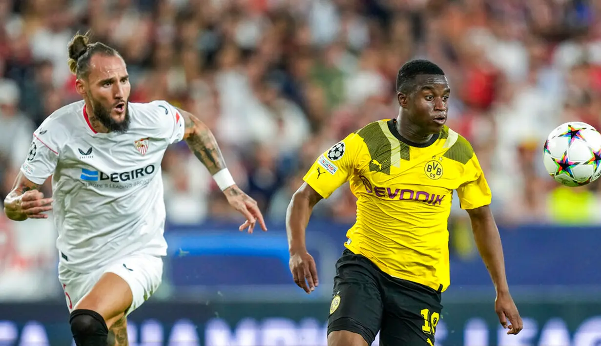 Pemain Borussia Dortmund Youssoufa Moukoko (kanan) berebut bola dengan pemain Sevilla Nemanja Gudelj pada pertandingan Grup G Liga Champions di Stadion Ramon Sanchez Pizjuan, Seville, Spanyol, 5 Oktober 2022. Borussia Dortmund menang 4-1. (AP Photo/Jose Breton)