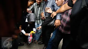 Sylviana Murni memungut sampah usai diperiksa Bareskrim di Gedung Ombudsman, Jakarta, Senin (30/1). Panggilan tersebut terkait pemeriksaan kasus dugaan korupsi pembangunan Masjid Al-Fauz. (Liputan6.com/Faizal Fanani)