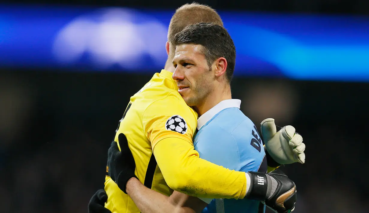 Bek City, Martin Demichelis (kanan) berpelukan dengan kiper , Joe Hart usai pertandingan melawan Dynamo Kiev pada leg kedua 16 besar Liga Champions di Stadion Etihad, Rabu (16/3). City berhasil masuk perempat final Liga Champion. (Reuters/Phil Noble)