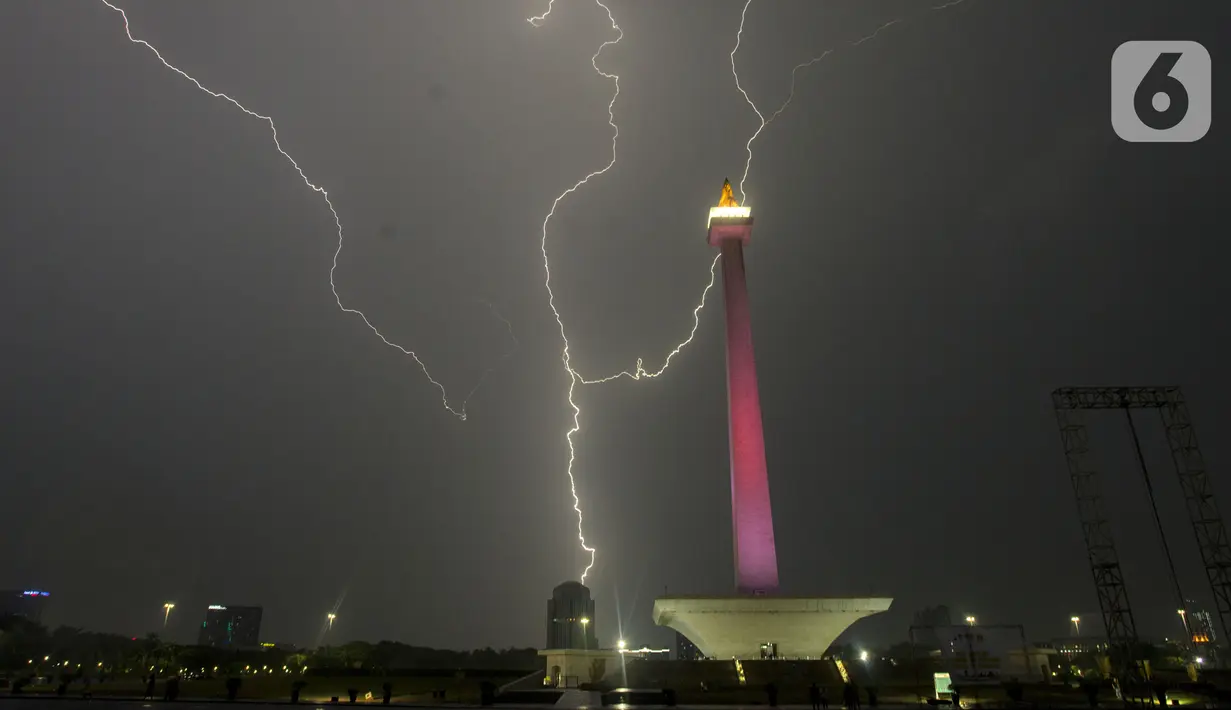 Kilatan petir menyambar di kawasan Monas, saat hujan yang disertai angin mengguyur Jakarta, Sabtu (21/12/2019),Malam. BMKG mengingatkan agar waspada terhadap potensi hujan deras yang disertai petir diprediksi akan terjadi dalam beberapa hari kedepan. (merdeka.com/Imam Buhori)