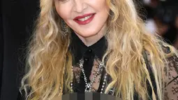 Senyum Madonna saat berpose menghadiri ajang Met Gala 2016 di Metropolitan Museum of Art, New York, Senin (2/5). Madonna hadir bersama desainer Riccardo Tisci dengan busana yang nyentrik dan transparan. (AFP/Larry Busacca)