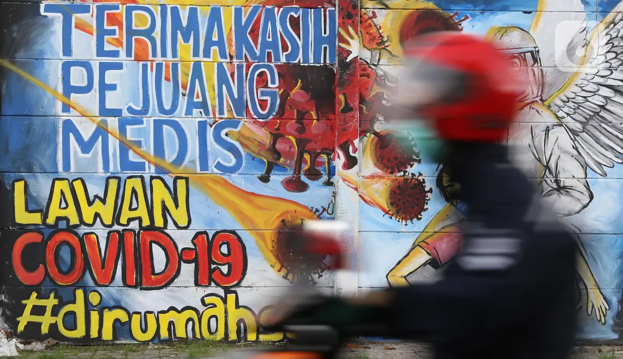 Pengendara motor melintasi mural ajakan melawan COVID-19 di Depok, Jawa Barat, Selasa (14/4/2020). Pemprov Jabar memulai pembatasan sosial skala besar di Bogor, Depok, Bekasi pada Rabu (15/4) dengan menyiapkan anggaran Rp4 triliun sebagai jaring pengaman sosial. (Liputan6.com/Helmi Fithriansyah)