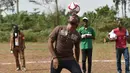 Mantan penyerang Chelsea, Didier Drogba berusaha mengontrol bola saat bermain dengan murid-murid saat peresmian sekolah di Pokou-Kouamekro, dekat Gagnoa, Pantai Gading tengah barat (17/1). (AFP Photo/Sia Kambou)