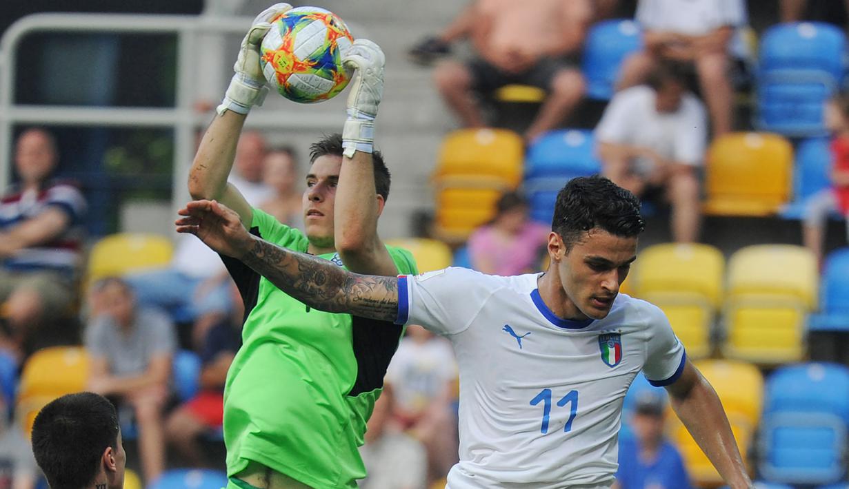 Kiper Ukraina, Andriy Lunin (kiri) berhasil menangkap bola dari ancaman pemain Italia, Gianluca Scamacca dalam laga semifinal Piala Dunia U-20 2019 di Gdynia, Polandia (11/6/2019). Andriy Lunin yang sejak awal musim 2018/2019 membela menjadi milik Real Madrid ini terpilih sebagai kiper terbaik pada Piala Dunia U-20 2019 Polandia. (AFP/Alik Keplicz)