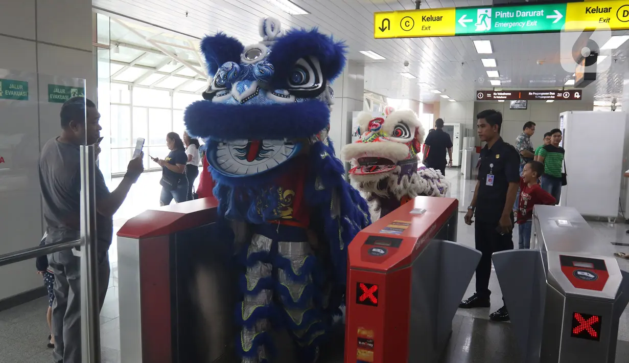 Atraksi Barongsai berkeliling untuk menghibur penumpang di Stasiun LRT Velodrome (25/1/2020). Pertunjukan tersebut dalam rangka perayaan tahun baru Imlek yang ke-2571. (Liputan6.com/Herman Zakharia)