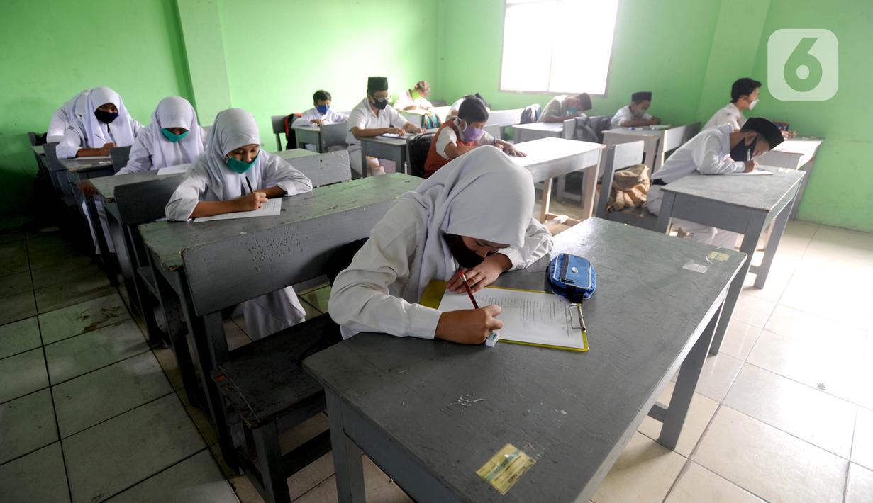 Murid baru menggunakan masker  mengikuti tes penentuan kelas tahun ajaran 2020-2021 yang selanjutnya akan mengikuti kegiatan belajar mengajar (KBM) secara darling di MTs Hidayatul Umami, Cinere, Depok, Jawa Barat, Senin (13/7/2020). (merdeka.com/Arie Basuk)