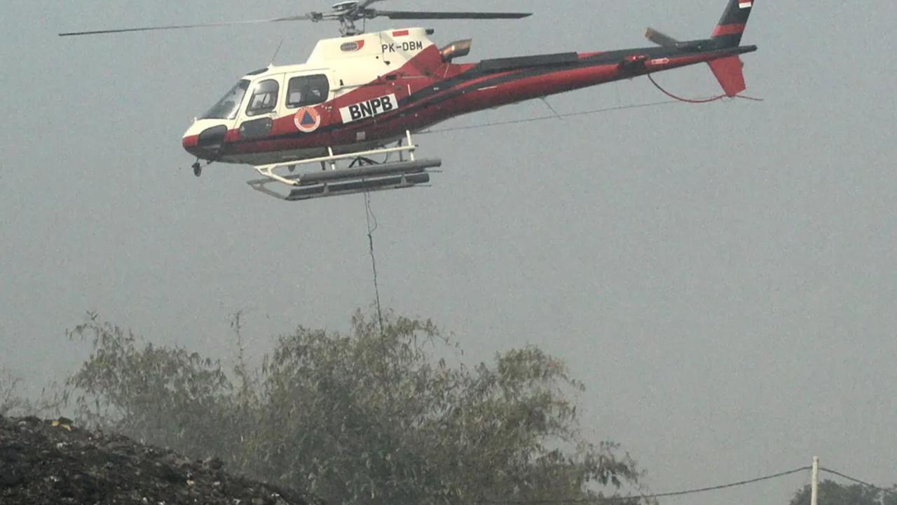 Helikopter Water Bombing  Badan Nasional Penanggulangan Bencana (BNPB) masih terus melakukan pemadaman api yang membakar tempat pembuangan akhir (TPA) Rawa Kucing, Neglasari, Kota Tangerang, Senin (23/10/2023).