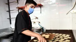 Seorang pedagang Suriah membuat "Qatayef", penganan manis tradisional yang biasa disajikan saat bulan suci Ramadan di Damaskus, Suriah, (18/5/2020). (Xinhua/Ammar Safarjalani)