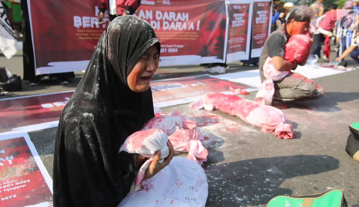 Relawan ACT melakukan teatrikal tentang penderita rakyat Suriah di CFD Bundaran HI, Jakarta, Minggu (15/7). Dalam aksinya relawan juga menggalang dana kemanusiaan untuk para warga sipil Suriah yang menjadi korban peperangan. (Liputan6.com/Arya Manggala)