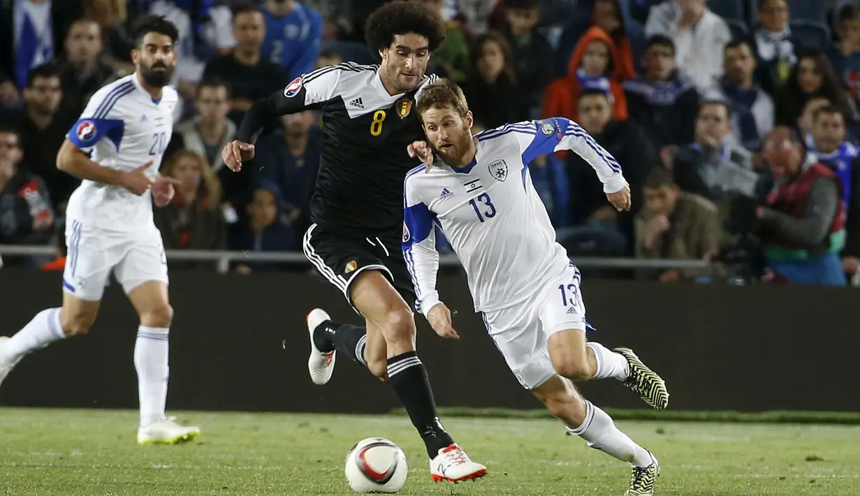 Gelandang Israel, Sheran Yeini berusaha melewati pemain Belgia Marouane Fellaini pada kualifikasi Piala Eropa 2016 di Teddi Malcha Stadium, Jerusalem,Rabu (1/4/2015). Belgia menang 1-0 melawan Israel. (REUTERS/Ronen Zvulun)