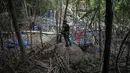 Petugas berjaga di sebuah kamp dilokasi kuburan massal di Wang Burma, dekat perbatasan Malaysia-Thailand, (26/5/2015). 139 kuburan massal yang berisi kerangka orang ditemukan.  (AFP PHOTO/MOHD RASFAN)