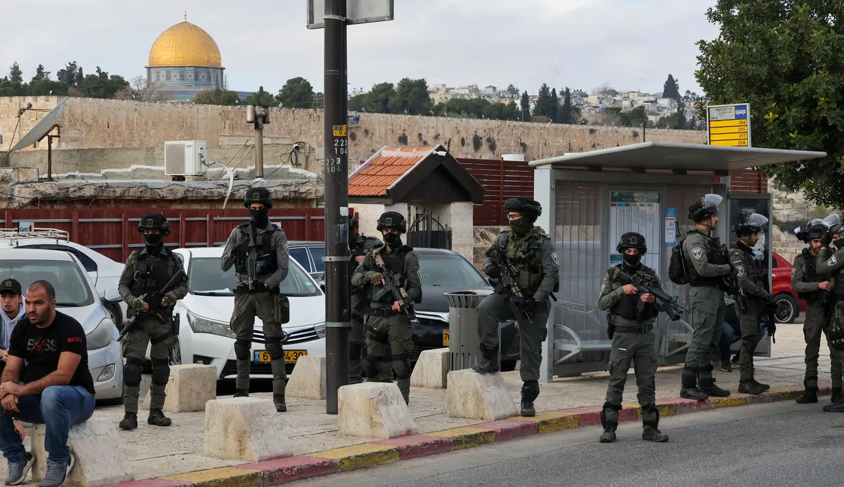 Masjid Kubah Batu terlihat di belakang pasukan keamanan Israel yang berjaga-jaga saat umat Islam Palestina berkumpul untuk salat Jumat di Yerusalem timur pada 29 Desember 2023. (AHMAD GHARABLI/AFP)