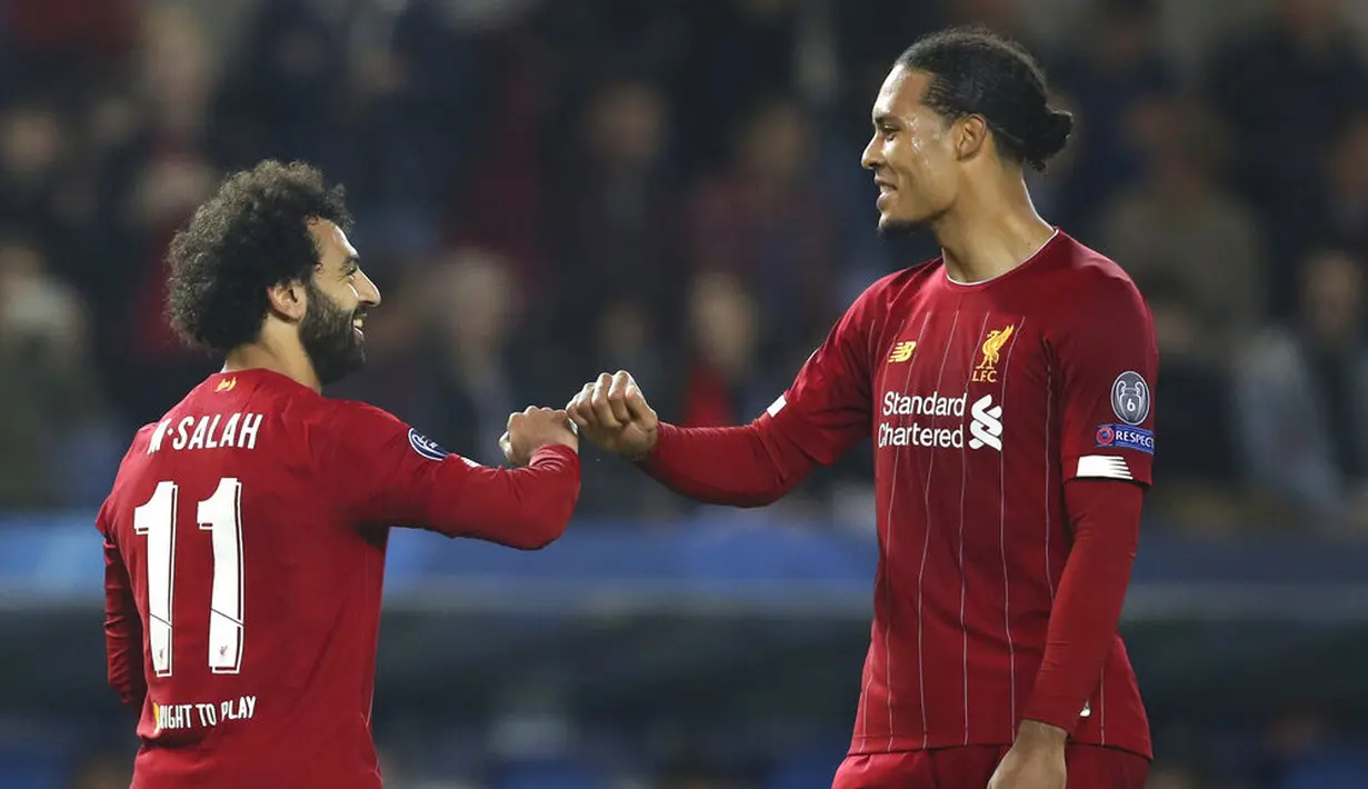 Penyerang Liverpool, Mohamed Salah bersama Virgil van Dijk merayakan gol ke gawang KRC Genk pada laga Liga Champions 2019 di KRC Genk Arena, Rabu (23/10). Liverpool menang 4-1 atas KRC Genk. (AP/Francisco Seco)