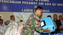 Salah satu anggota TNI memperlihatkan barang yang diduga milik penumpang pesawat AirAsia QZ8501, Pangkalan Bun, Kalteng, Selasa (30/12/2014). (Liputan6.com/Miftahul Hayat)