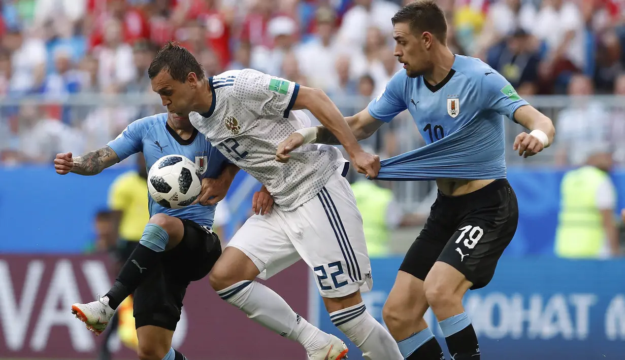 Pemain Rusia, Artyom Dzyuba (tengah) berusaha melewati adangan dua pemain Uruguay  pada laga grup A Piala Dunia 2018 di Samara Arena, Samara, Rusia, (25/6/2018). Uruguay menang 3-0. (AP/Hassan Ammar)