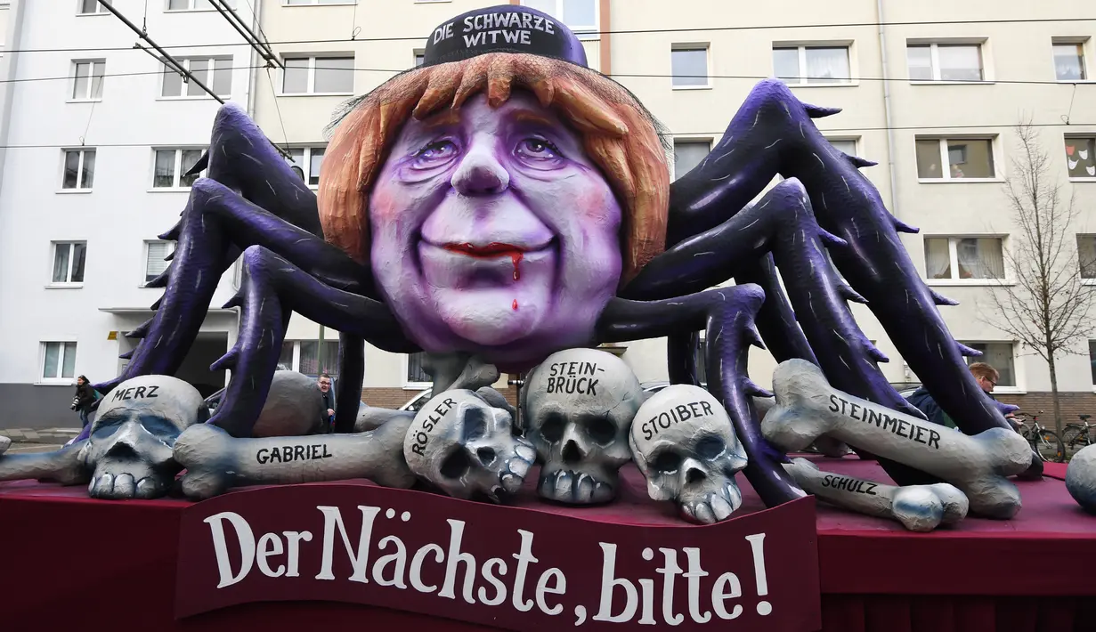 Sebuah kereta karnaval membawa karikatur yang menggambarkan kanselir Jerman, Angela Merkel sebagai Black Widow dengan tulisan "Yang berikutnya, tolong!" dalam parade karnaval Rose Monday di Mainz, Jerman barat, Senin (12/2). (Patrik STOLLARZ/AFP)