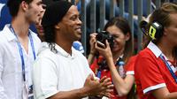 Legenda sepakbola Brasil, Ronaldinho menghadiri seremonial final Piala Dunia 2018 antara Prancis vs Kroasia di Stadion Luzhniki, Minggu (15/7). Ronaldinho sukses menghadirkan kemeriahan sebelum laga final bergulir. (AFP/FRANCK FIFE)
