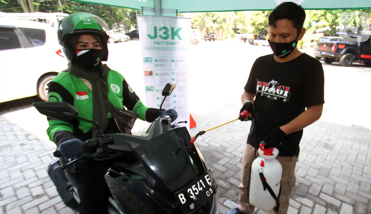 Petugas meyemprotkan cairan disinfektant pada mitra Gojek di Kota Depok, Jawa Barat, Jumat (18/8/2020). Aksi J3K (Jaga Kesehatan-Jaga Kebersihan-Jaga Keamanan) dalam rangka Hari Perhubungan Nasional berkomitmen untuk melawan Covid-19 dengan menyediakan ribuan masker. (Liputan6.com/HO/Ading)