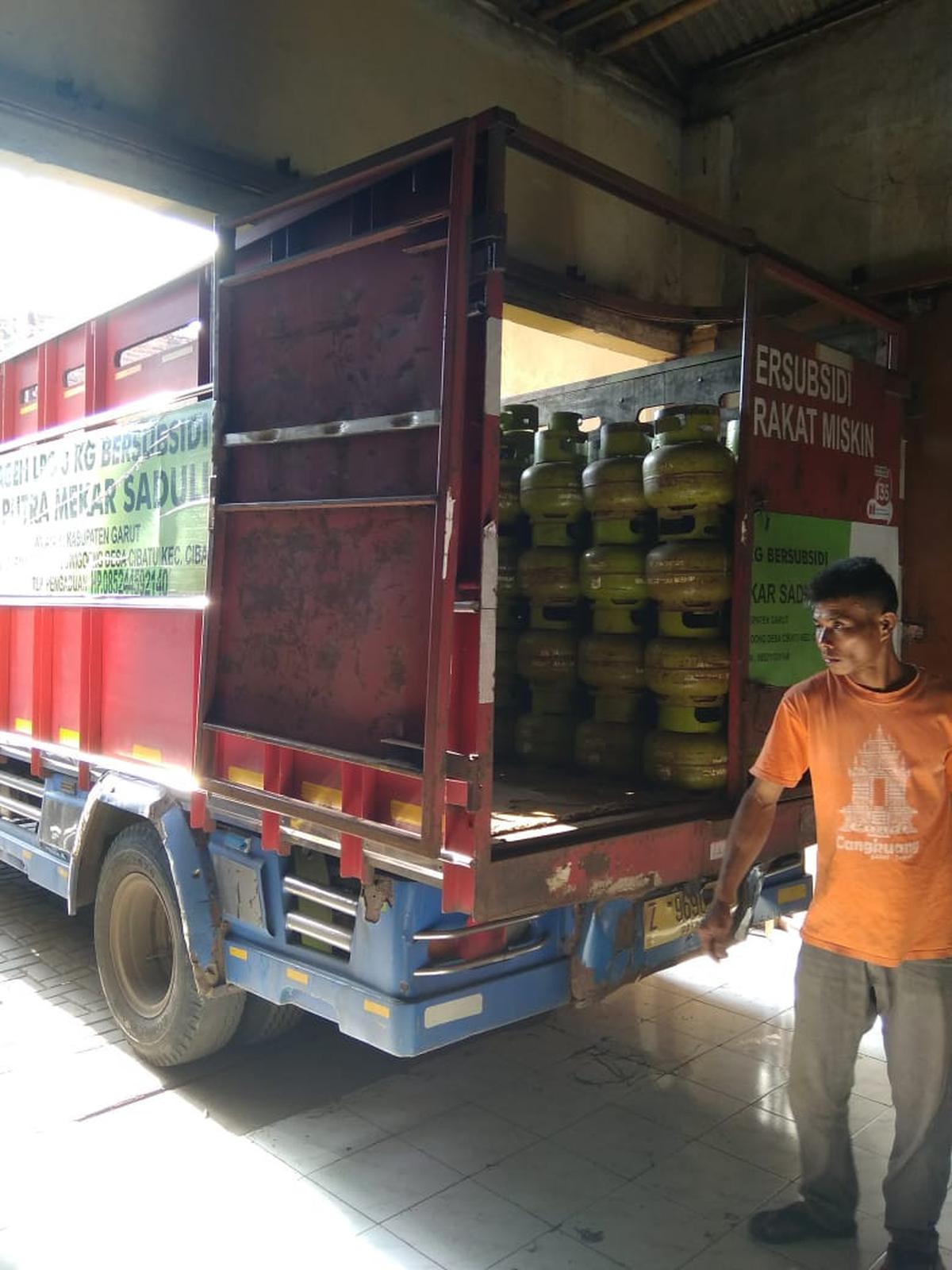 Salah seorang pegawai agen gas LPG 3 kg tengah menaikan gas melon ke salah satu mobil angkutan gas bersubisi di Garut, Jawa Barat. (Liputan6.com/Jayadi Supriadin)