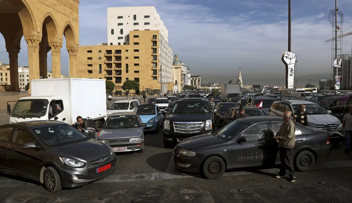 Pengemudi taksi memblokir jalan dengan kendaraan mereka selama aksi protes di Martyrs' Square, di pusat kota Beirut, Lebanon, Selasa (30/11/2021). Mereka memprotes kenaikan harga bensin, barang-barang konsumsi dan jatuhnya mata uang pound Lebanon. (AP Photo/Bilal Hussein)