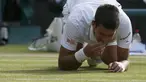 Petenis Novak Djokovic memakan rumput lapangan usai memastikan diri menjadi juara Wimbledon, London, Minggu (6/7/14). (REUTERS/Stefan Wermuth)