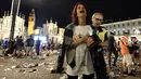 Seorang wanita menangis usai terjadi ledakan saat nonton bareng final Liga Champions di Piazza San Carlo, Turin, Sabtu (3/6/2017). Acara nobar dipadati sekitar 20.000 supporter Juventus. (AFP/Massimo Pinca)