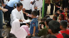 Presiden Joko Widodo (Jokowi) membagi-bagikan buku tulis untuk anak-anak saat meninjau tenda pengungsian korban gempa Aceh di Pidie Jaya, Jumat (9/12). Selain buku tulis, Jokowi juga membagikan kotak pensil kepada warga. (Liputan6.com/Angga Yuniar)