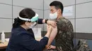 Seorang tentara Korea Selatan menerima dosis pertama vaksin virus corona COVID-19 AstraZeneca di Rumah Sakit Pusat Angkatan Bersenjata, Seongnam, selatan Seoul, Rabu (28/4/2021). Militer Korea Selatan mulai menjalani vaksinasi COVID-19. (Handout/South Korean Defence Ministry/AFP)