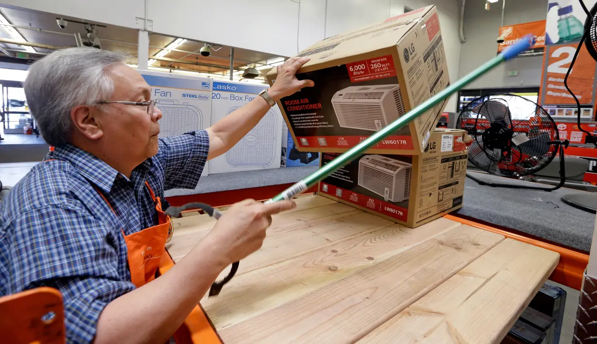 Manager toko mengambilkan pendingin udara untuk pelanggan menjelang gelombang panas di toko perlengkapan Home Depot di Seattle, Selasa (1/8). Suhu panas mendekati 100 derajat diperkirakan terjadi di wilayah itu pada Kamis 3 Agustus. (AP/Elaine Thompson)
