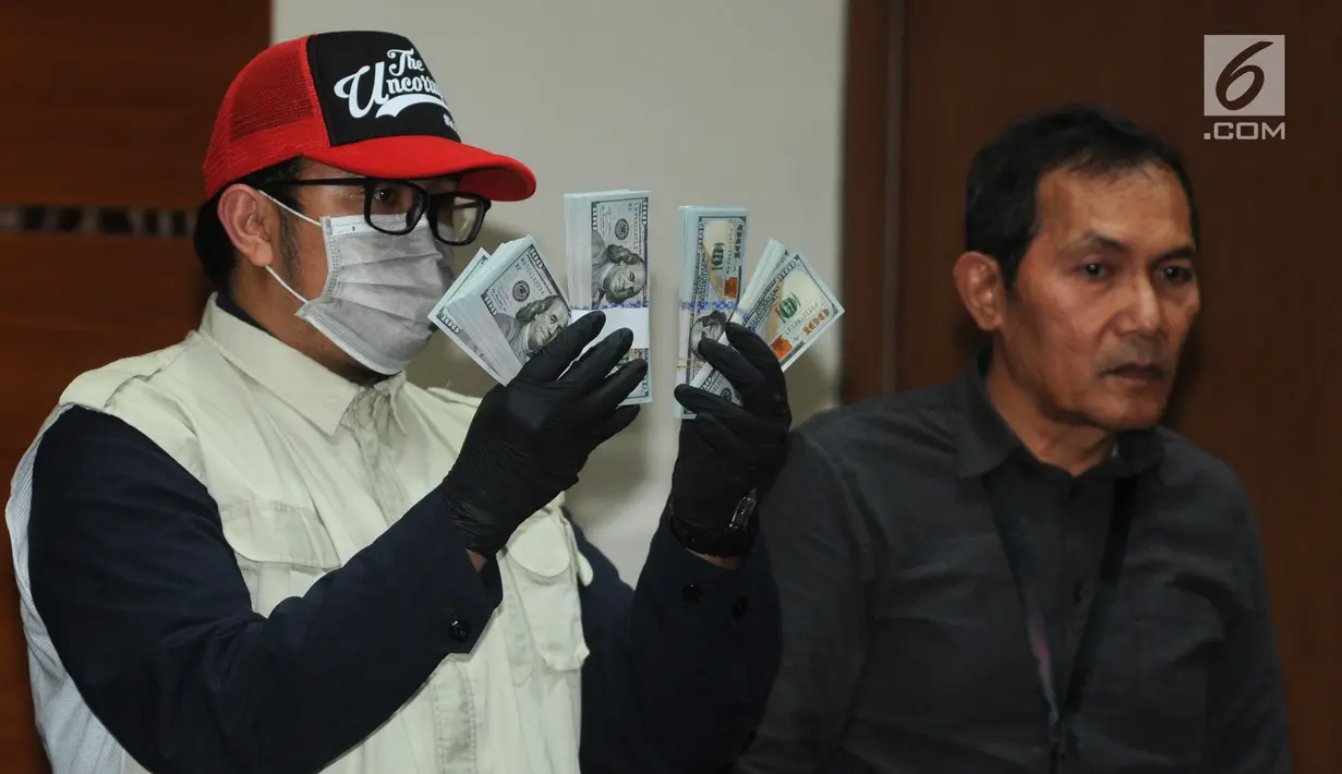 Petugas menunjukkan barang bukti uang sebesar USD 30 ribu hasil OTT kasus dugaan suap kuota impor ikan di Gedung KPK, Jakarta, Selasa (24/09/2019). KPK menemukan adanya dugaan alokasi fee Rp 1.300 untuk setiap kilogram ikan yang diimpor. (merdeka.com/Dwi Narwoko)