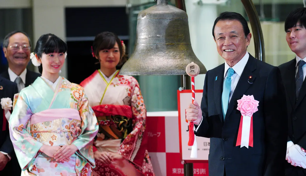 Menteri Keuangan Jepang Taro Aso (kanan) saat akan membunyikan lonceng saat upacara pembukaan Bursa Efek Tokyo di Tokyo, Jepang, Jumat (4/1). Bursa Efek Tokyo menggelar seremoni dalam pembukaan perdagangan saham 2019. (AP Photo/Eugene Hoshiko)