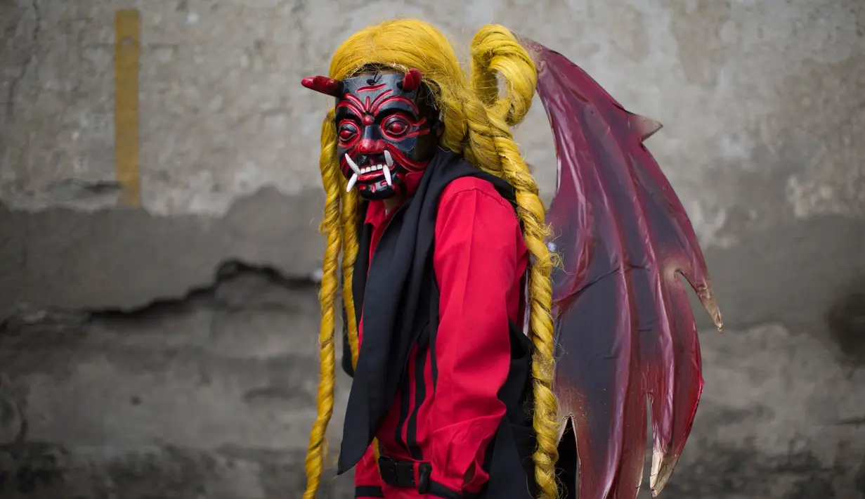 Remaja bernama Bryan Gonzalez mengenakan kostum iblis saat mengikuti prosesi perayaan Virgin of the Immaculate Conception di Ciudad Vieja, Guatemala (7/12). Parade ini digelar setiap tahun pada tanggal 8 Desember. (AP Photo/Luis Soto)