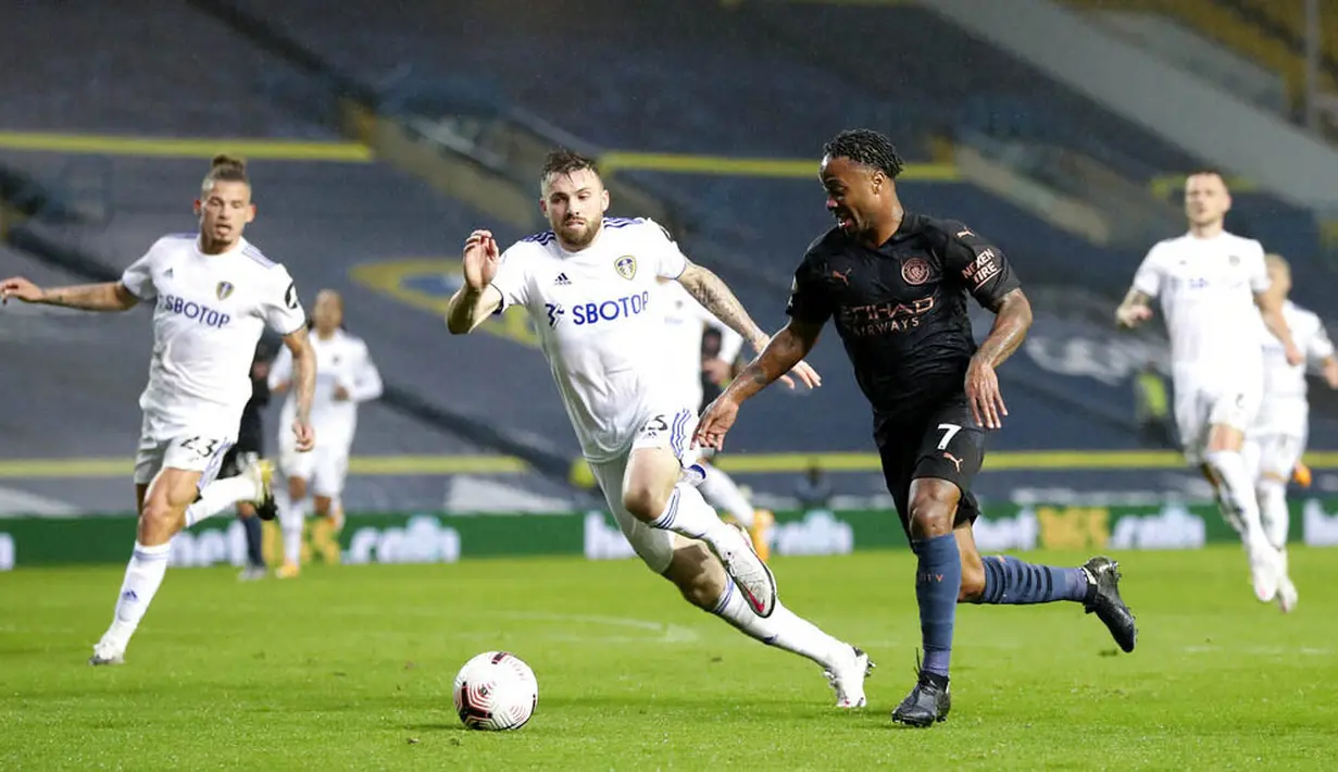 Penyerang Manchester City, Raheem Sterling, berusaha melewati pemain Leeds United pada laga Liga Inggris di Stadion Elland Road, Sabtu (3/10/2020). Kedua tim bermain imbang 1-1. (Cath Ivill/Pool via AP)