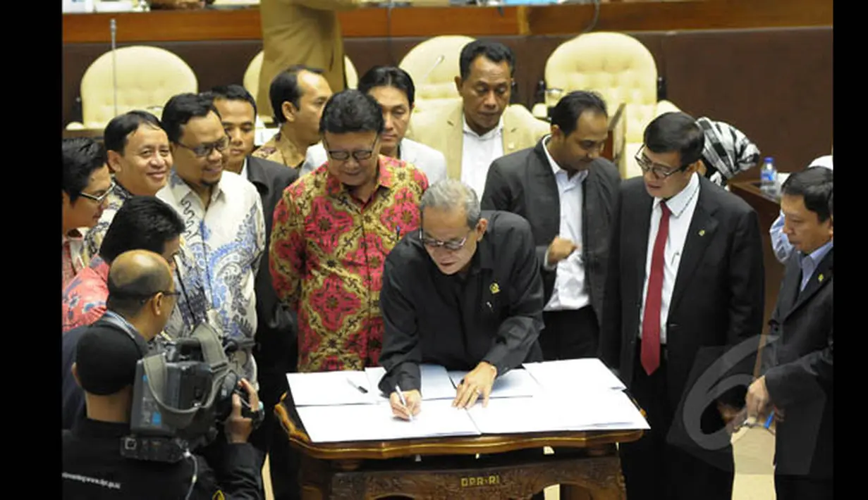 Ketua Komisi II DPR-RI Rambe Kamaru Saman menandatangani Perppu Pilkada dalam rapat kerja bersama Menkumham Yasonna dan Mendagri Tjahjo Kumolo di Gedung Nusantara, Kompleks Parlemen Senayan, Jakarta, Senin (19/1/2015). (Liputan6.com/Andrian M Tunay)