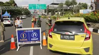 Petugas gabungan mengarahkan kendaraan saat penerapan ganjil genap di Jalan Raya Puncak, Gadog, Kabupaten Bogor, Jawa Barat, Jumat (3/9/2021). Jika uji coba tersebut efektif mengurai kepadatan akan dilanjutkan terus setiap akhir pekan. (Liputan6.com/Herman Zakharia)